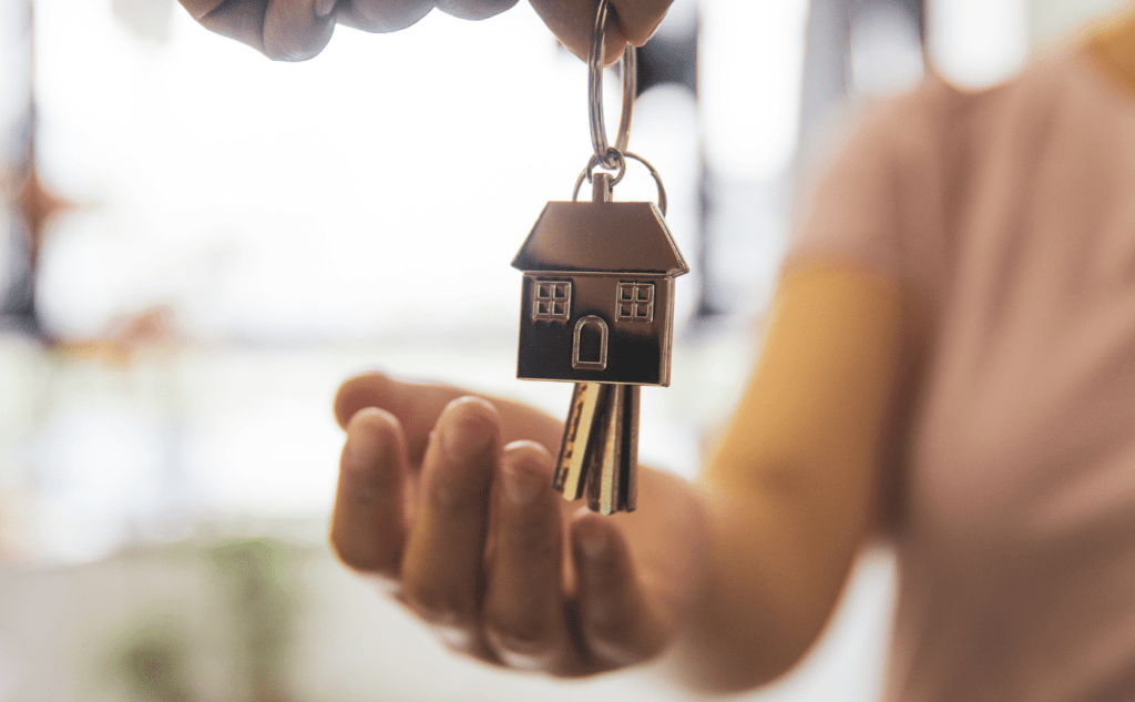 Handing someone keys to new home with house keyring attached
